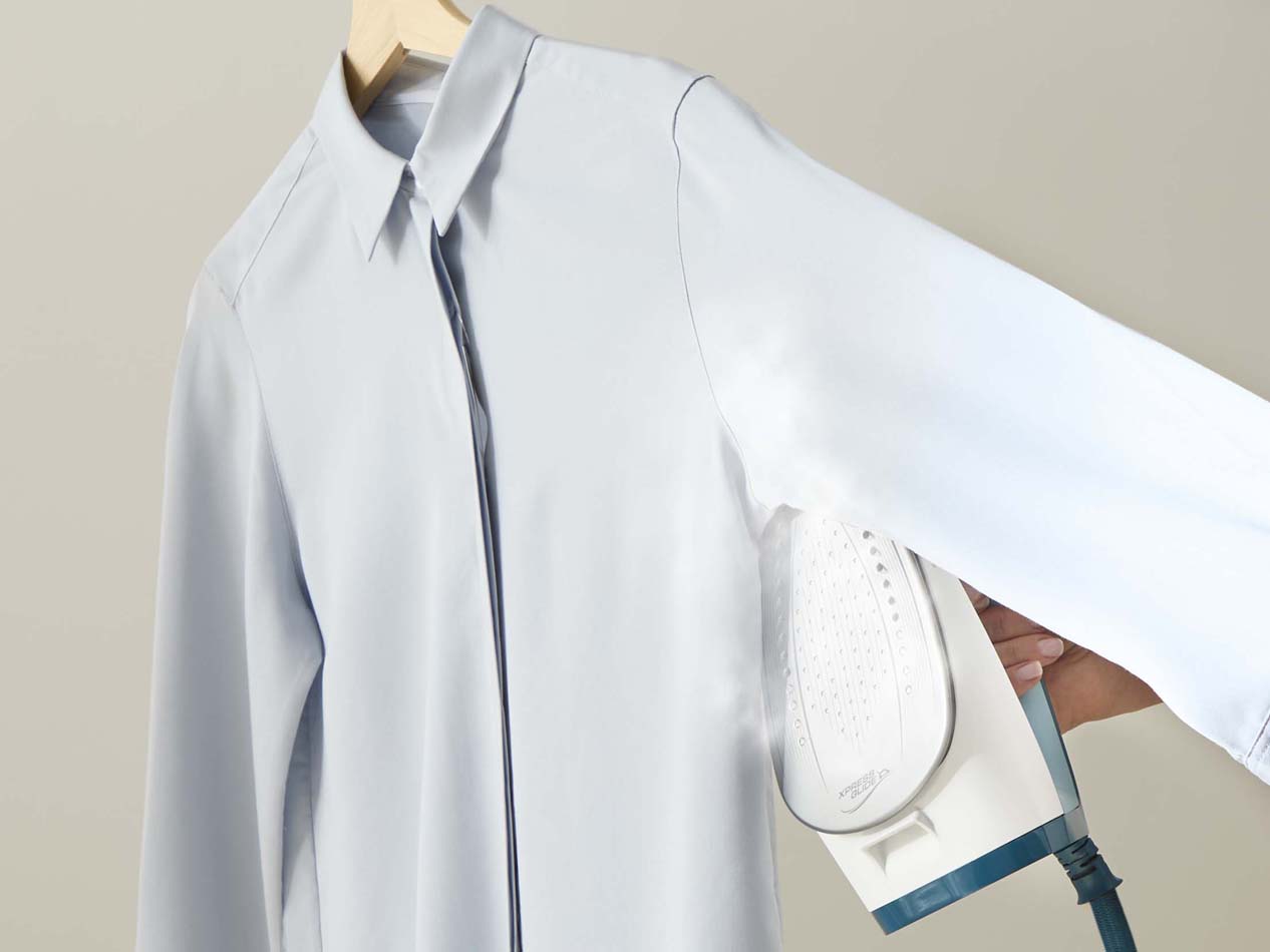 5.Stryg forstykket omhyggeligt: start ved stolpelukningen, stryg mellem knapperne og glat resten for et pænt skjorteresultat.